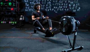 A man trying a best budget Rowing Machine for weight loss in a gym.