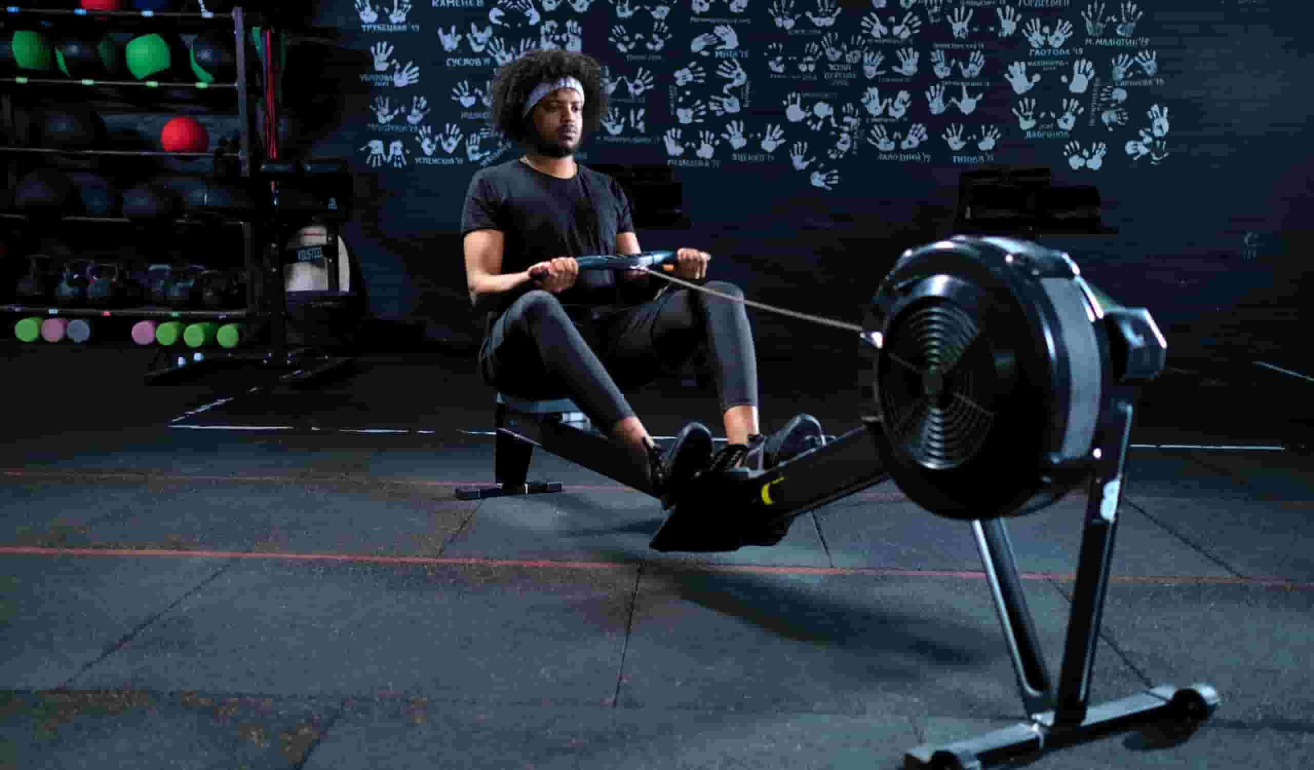 A man trying a best budget Rowing Machine for weight loss in a gym.