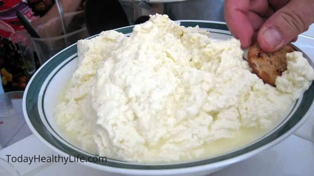 A full plate of ricotta cheese with a man's hand.  Can you freeze ricotta cheese?